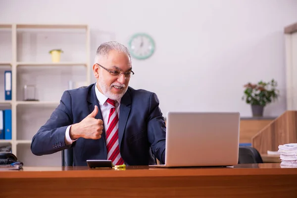 Gammal manlig anställd som sitter på kontoret — Stockfoto