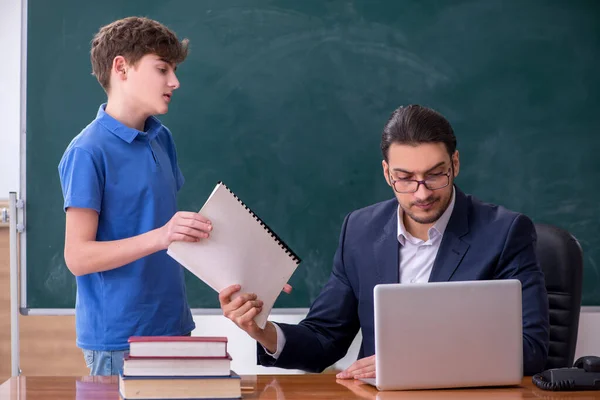 Jeune enseignant et écolier dans la salle de classe — Photo