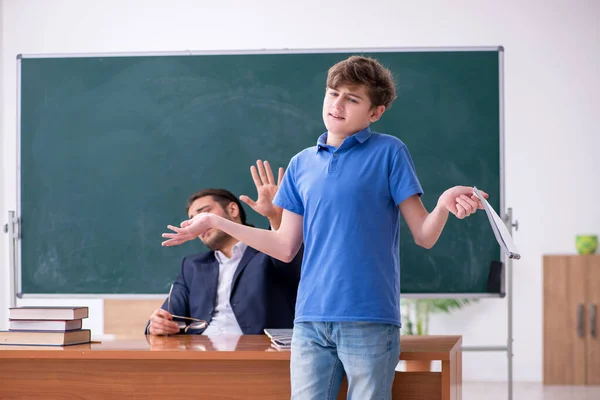 Jonge mannelijke leraar en schooljongen in de klas — Stockfoto