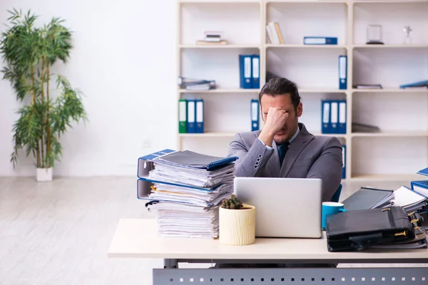 Joven empleado masculino infeliz con el trabajo excesivo — Foto de Stock