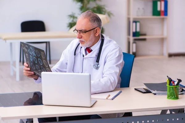 Starý lékař radiolog pracující na klinice — Stock fotografie