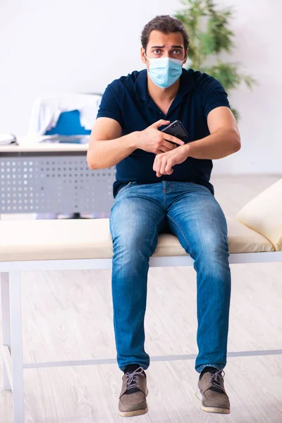 Jeune homme attendant un médecin pendant une pandémie à l'hôpital — Photo