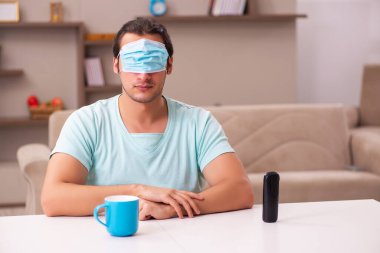 Genç adam salgın sırasında evde oturuyor.