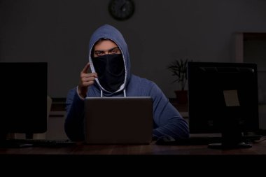 Erkek bilgisayar korsanı, güvenlik duvarını geç saatlerde hackliyor.