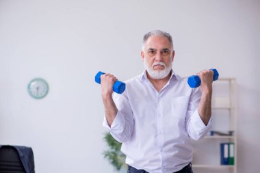 Mola sırasında fiziksel egzersiz yapan yaşlı bir erkek.
