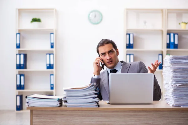 Giovane dipendente maschio infelice con il lavoro eccessivo — Foto Stock