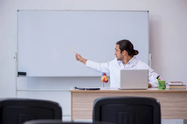 Jonge mannelijke arts geeft seminar in de klas — Stockfoto