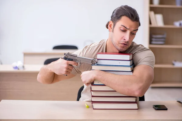 Jonge mannelijke student bereidt examens in de bibliotheek voor — Stockfoto