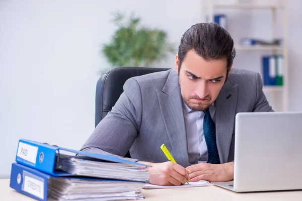 Junge männliche Angestellte unzufrieden mit exzessiver Arbeit im Büro — Stockfoto