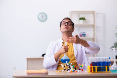 Sınıftaki genç erkek kimyacı öğretmen.