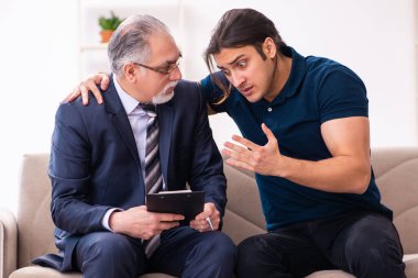 Genç adam yaşlı erkek psikoloğu ziyaret ediyor.