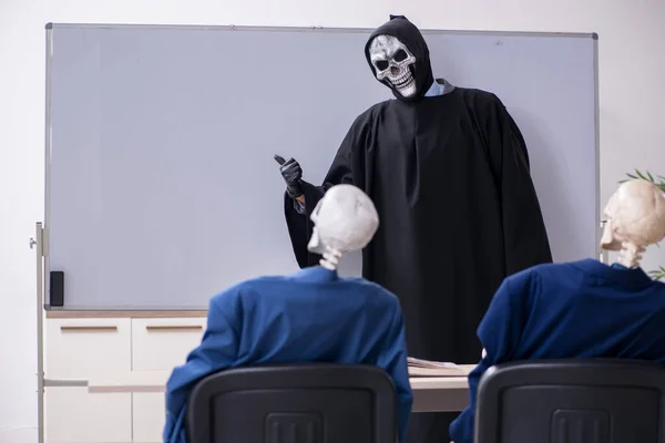 Забавная деловая встреча с дьяволом и скелетами — стоковое фото