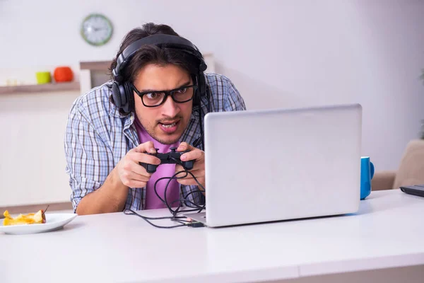 Evde bilgisayar oyunu oynayan genç bir erkek öğrenci — Stok fotoğraf