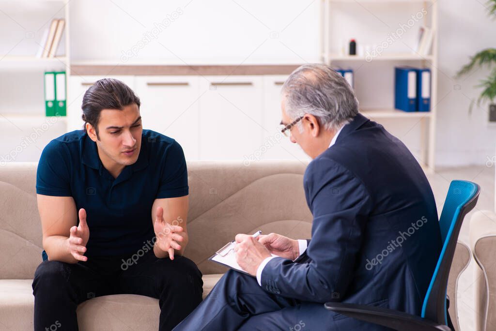 Young man visiting old male psychologist
