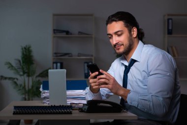 Genç işadamı ofiste geç saatlere kadar çalışıyor.