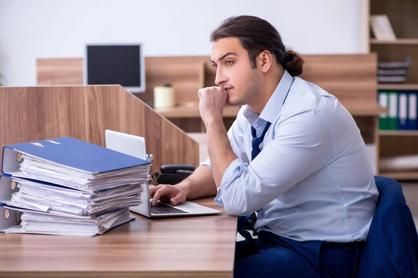 Jonge mannelijke werknemer ongelukkig met overmatig werk — Stockfoto