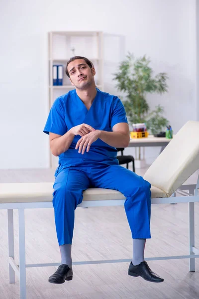 젊은 남성 의사가 병원에서 극도로 피곤 해 하는 모습 — 스톡 사진