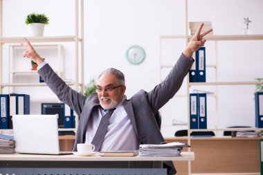 Ofiste çalışan yaşlı bir erkek.