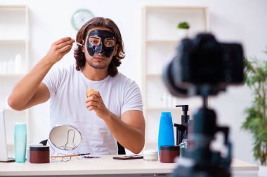Genç erkek kozmetikçi blogu için video kaydediyor.