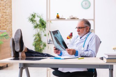 Hastanede çalışan yaşlı doktor radyoloji uzmanı.