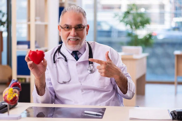 Viejo médico cardiólogo que trabaja en la clínica —  Fotos de Stock
