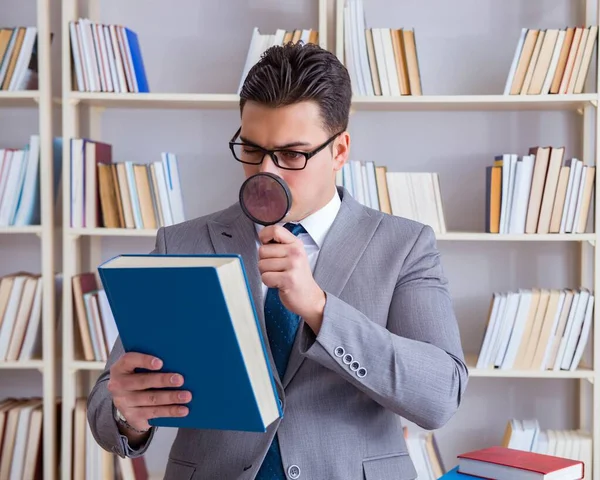 Mahasiswa hukum bisnis dengan kaca pembesar membaca buku — Stok Foto