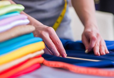 Kadın terzi dikiş dikmek için dikiş dikiyor.