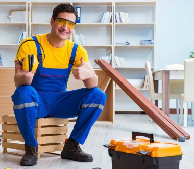 Tamirci marangoz tahta kalaslarla çalışıyor.