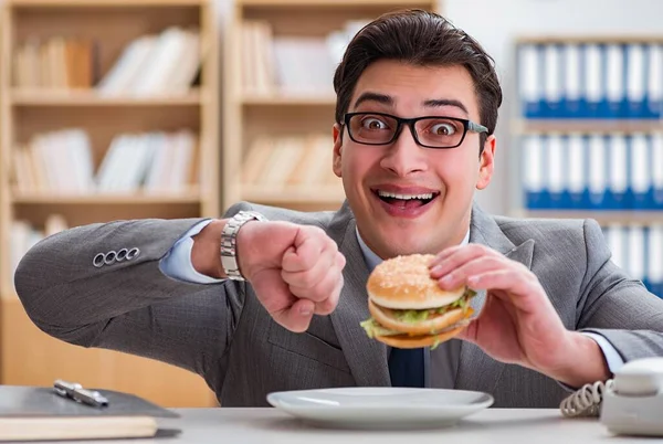 Hungrig rolig affärsman äter skräpmat smörgås — Stockfoto