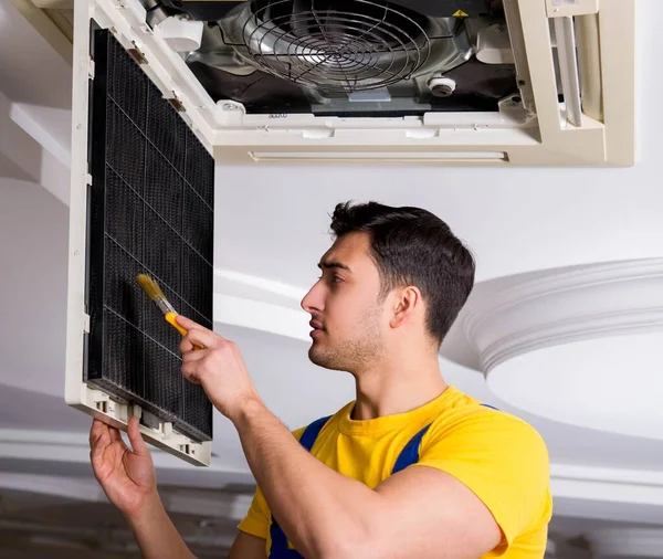 Repairman repairing ceiling air conditioning unit — Stock Photo, Image