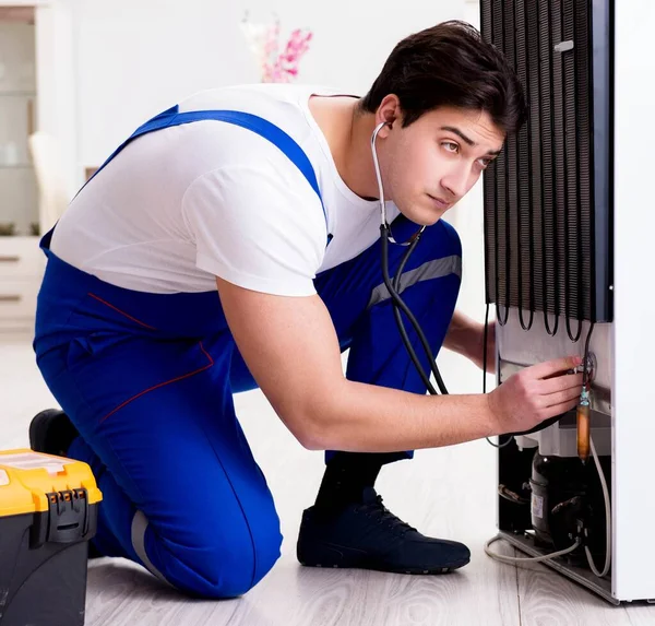 Tamirci müteahhit DIY konseptinde buzdolabını tamir ediyor. — Stok fotoğraf