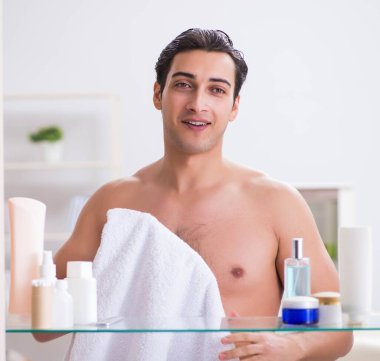 Genç adam banyoda çalışmak için hazırlanıyor.