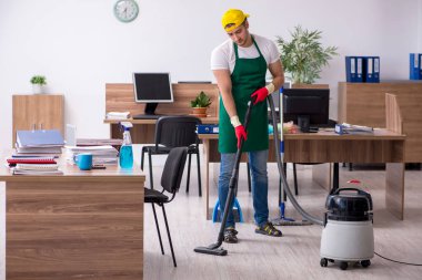 Genç müteahhit ofisi temizliyor.