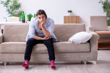 Genç alkolik erkek evde şarap içiyor.