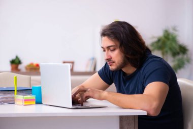 Evden çalışan genç bir adam.