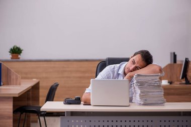 Genç bir erkek işçi aşırı işten memnun değil.