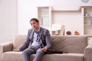 Yorgun genç işadamı işten sonra eve geliyor.