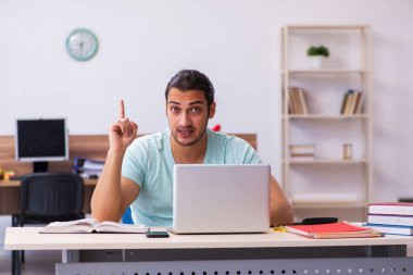 Tele-eğitimde sınavlara hazırlanan genç bir erkek öğrenci