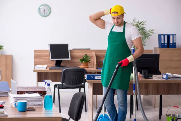 Jovem empreiteiro limpando o escritório — Fotografia de Stock