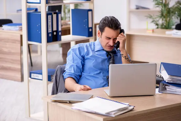 Ung affärsman anställd missnöjd med överdrivet arbete i o — Stockfoto