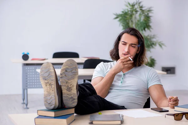 Mladý muž student kouření cigarety ve třídě — Stock fotografie