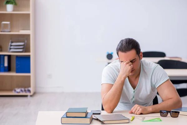 Joven estudiante masculino preparándose para el examen en el aula —  Fotos de Stock