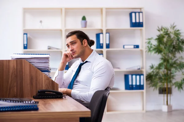 Молодий чоловік-працівник незадоволений надмірною роботою в офісі — стокове фото