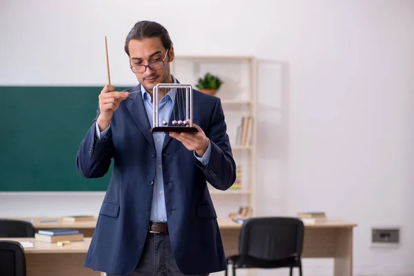 Young male teacher physicist in front of green board — Stock Photo, Image