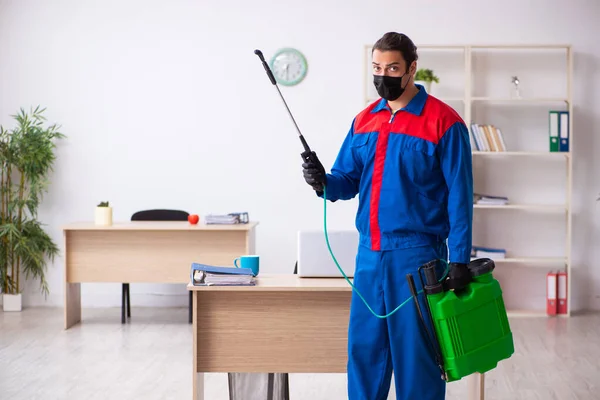 Contratista masculino joven desinfectando oficina — Foto de Stock