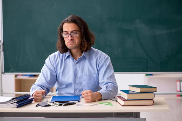 Jonge mannelijke leraar in de voorkant van groene boord — Stockfoto