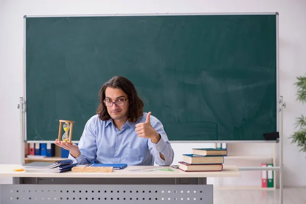 Молодий вчитель чоловічої статі перед зеленою дошкою — стокове фото