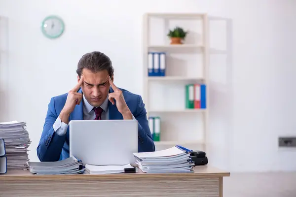 Jovem funcionário masculino infeliz com excesso de trabalho no escritório — Fotografia de Stock