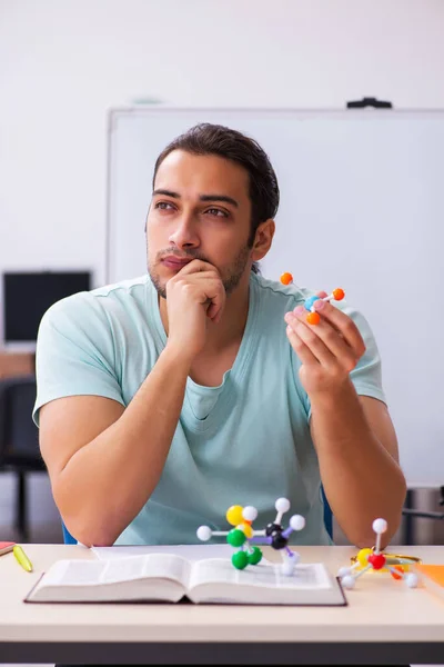 Молодий студент-фізик вивчає молекулярну модель вдома — стокове фото
