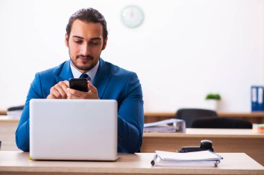 Genç bir erkek işçi ve ofiste çok fazla iş var.